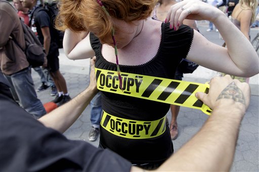 "Occupy" security-style tape is stuck to Laura Nagy during an Occupy Wall Street anniversary concert in Foley Square in New York on Sunday, Sept. 16, 2012. (AP/Seth Wenig)