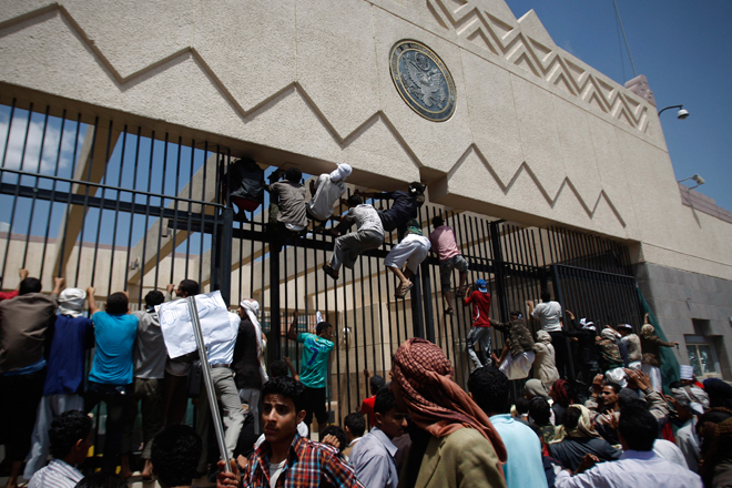 Yemeni protestors climb the gate of the U.S. Embassy during a protest about a film ridiculing Islam's Prophet Muhammad, in Sanaa, Yemen, Thursday, Sept. 13, 2012. (AP/Hani Mohammed)