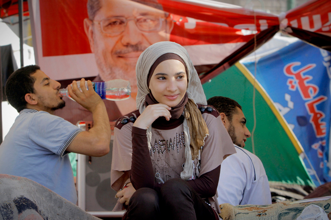 Egyptian protesters sit in front of a tent decorated by a poster of Egypt's President-elect Mohammed Morsi in Tahrir Square in Cairo in June. (AP/Amr Nabil)