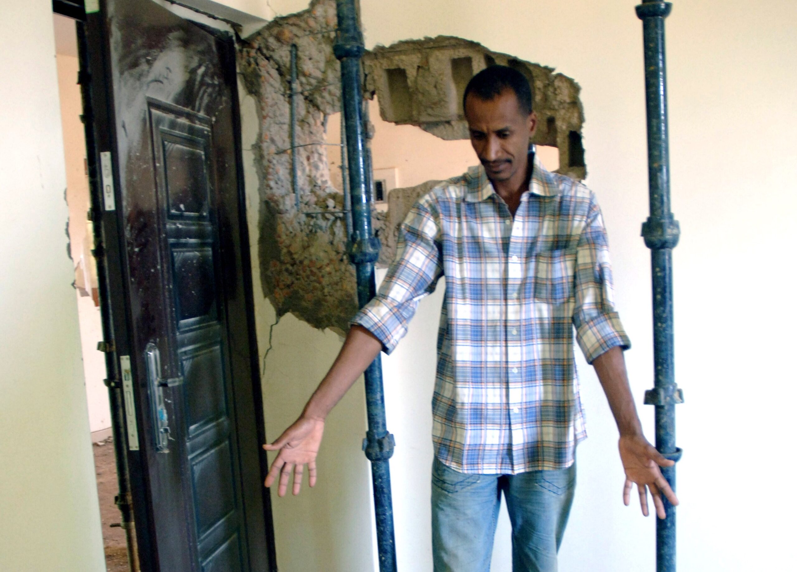 A Sudanese man shows damages in his home caused by an artillery shell in Khartoum, Sudan. (AP/Abd Raouf)