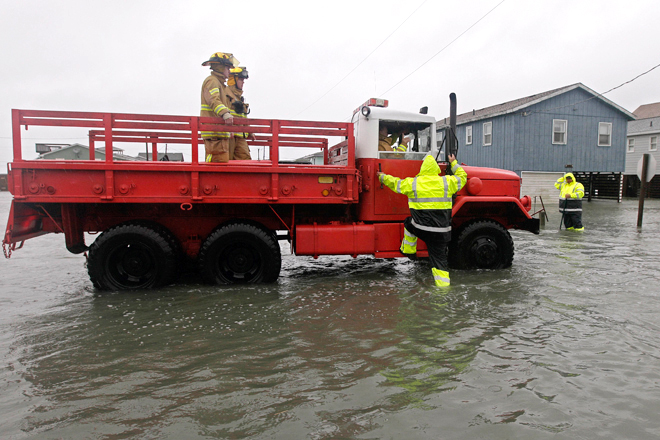 A Dare County utility worker checks with the Kitty Hawk Fire Department as they patrol flooded streets in Kitty Hawk, N.C., Monday, Oct. 29, 2012. (AP/Gerry Broome)