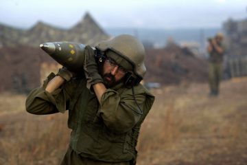 An Israeli soldier carries shells on the border with Lebanon in 2006 (David Furst//Getty Images)