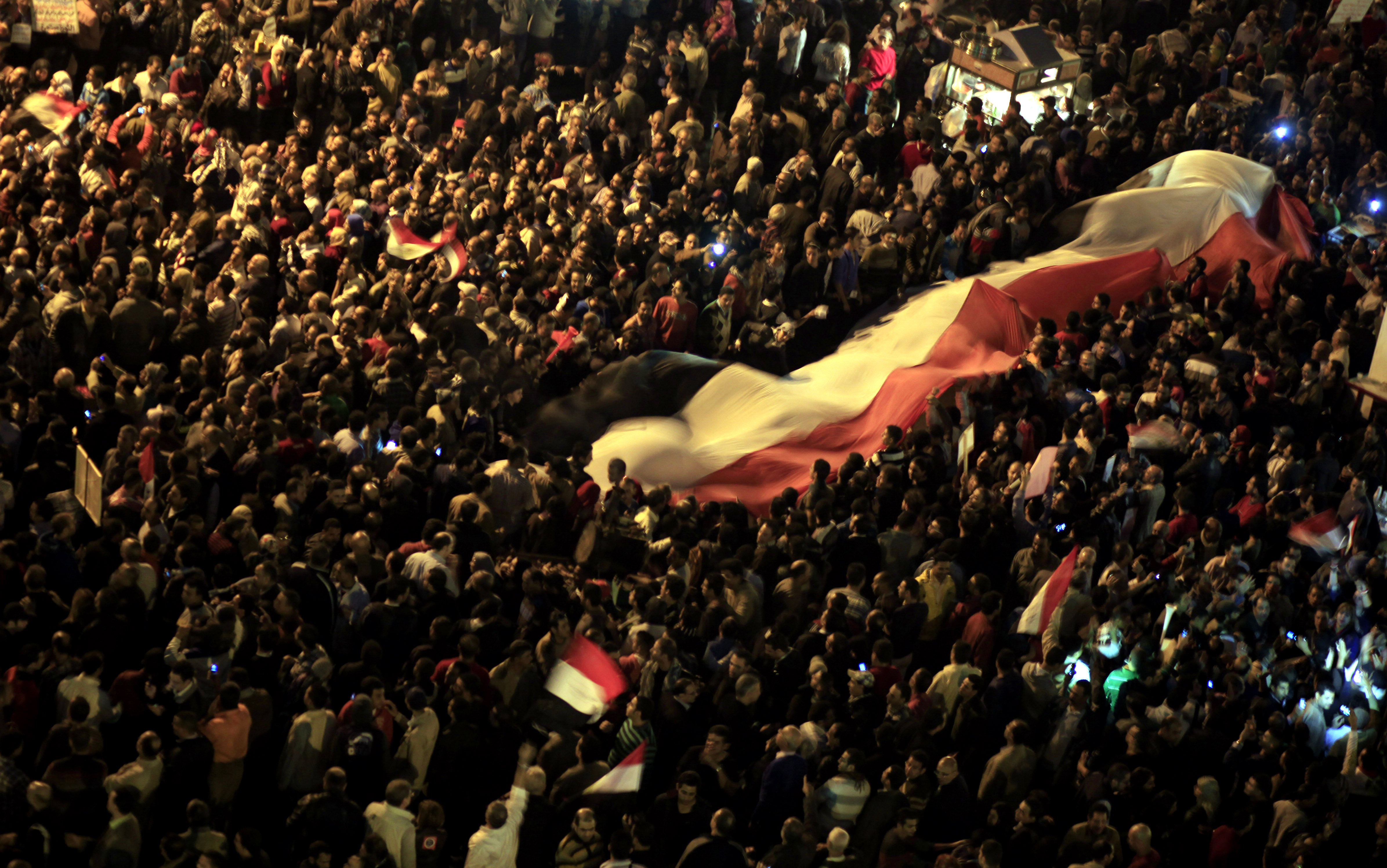 Egyptian protesters unfurl a large national flag at an opposition rally in Tahrir Square in Cairo, Egypt. (AP/Khalil Hamra)