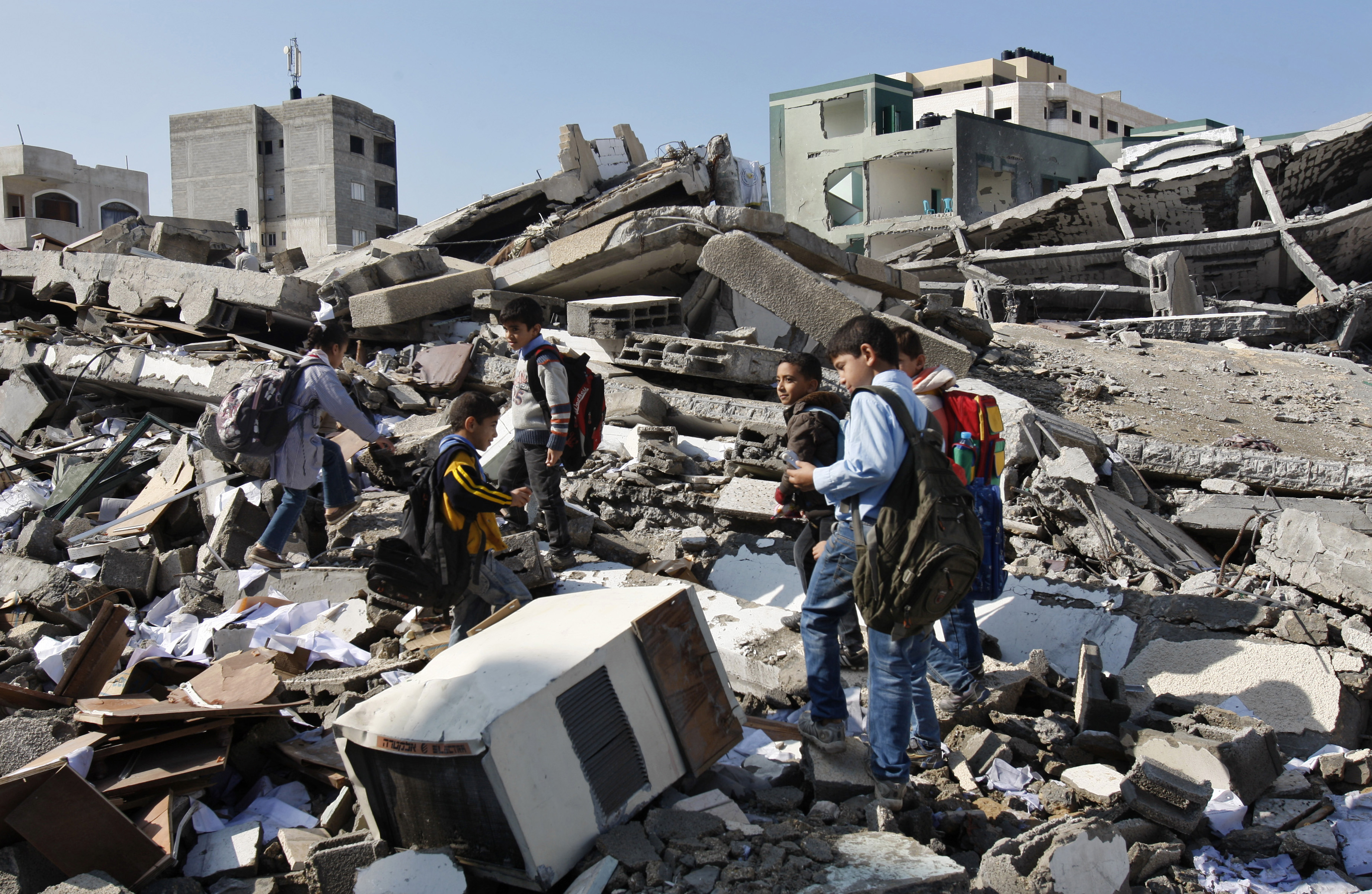 Palestinian school children walk in the rubble left days after an Israeli strike destroyed the Hamas interior ministry in Gaza City. (AP/Adel Hana)