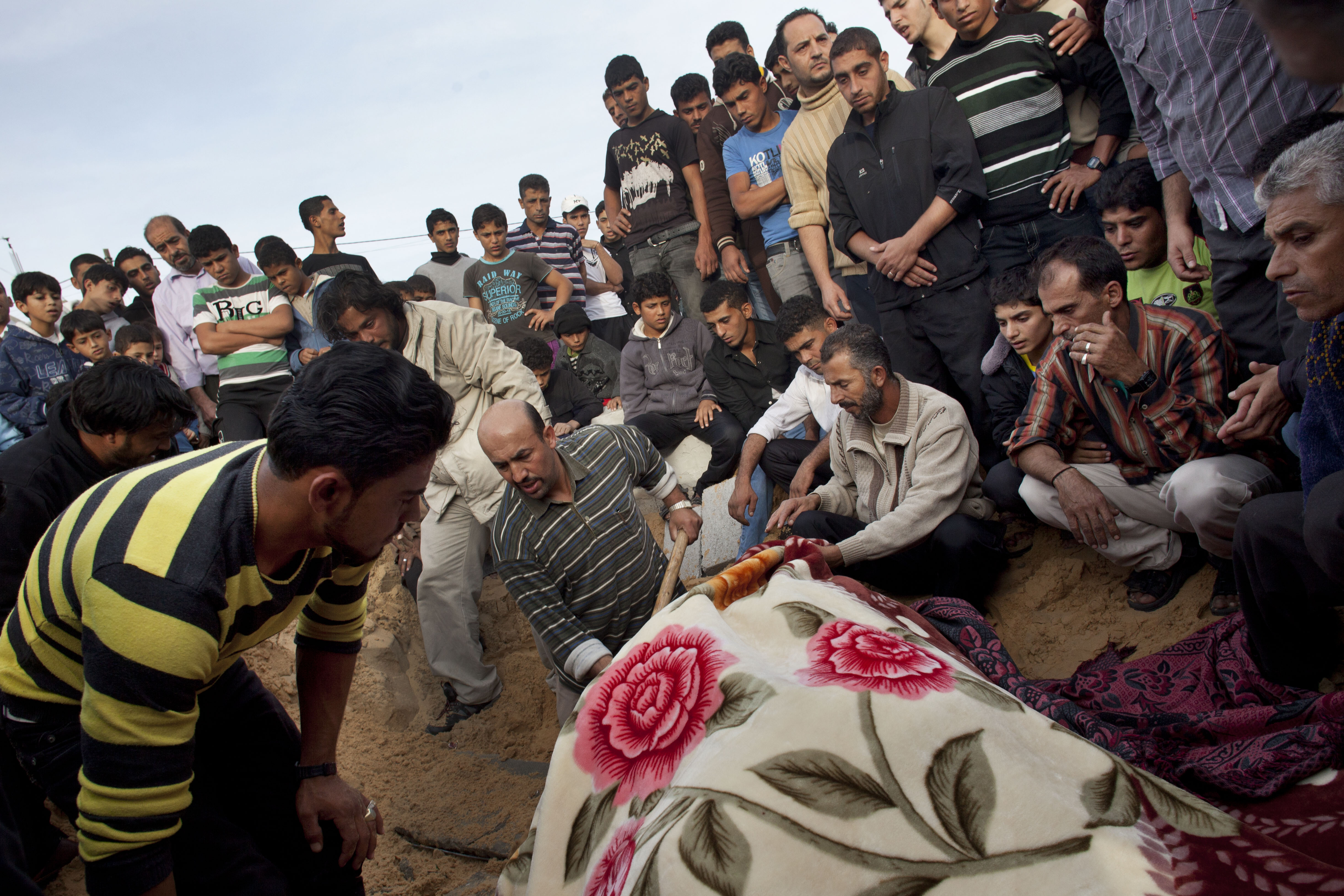 Palestinians bury the body of Tahrer Salman, covered with a blanket, during her funeral in Beit Lahia, north Gaza, Friday, Nov. 16, 2012.  According to relatives, Tahrer Salman and Mohammed Salman were killed after an Israeli airstrike hit the yard of their house. (AP/Bernat Armangue)