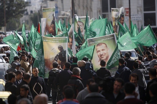 Hamas supporters in the West Bank city of Ramallah carry obituary posters of Hamas mastermind Ahmed Jabari as they march in support of the people of the Gaza Strip. (AP/Majdi Mohammed)