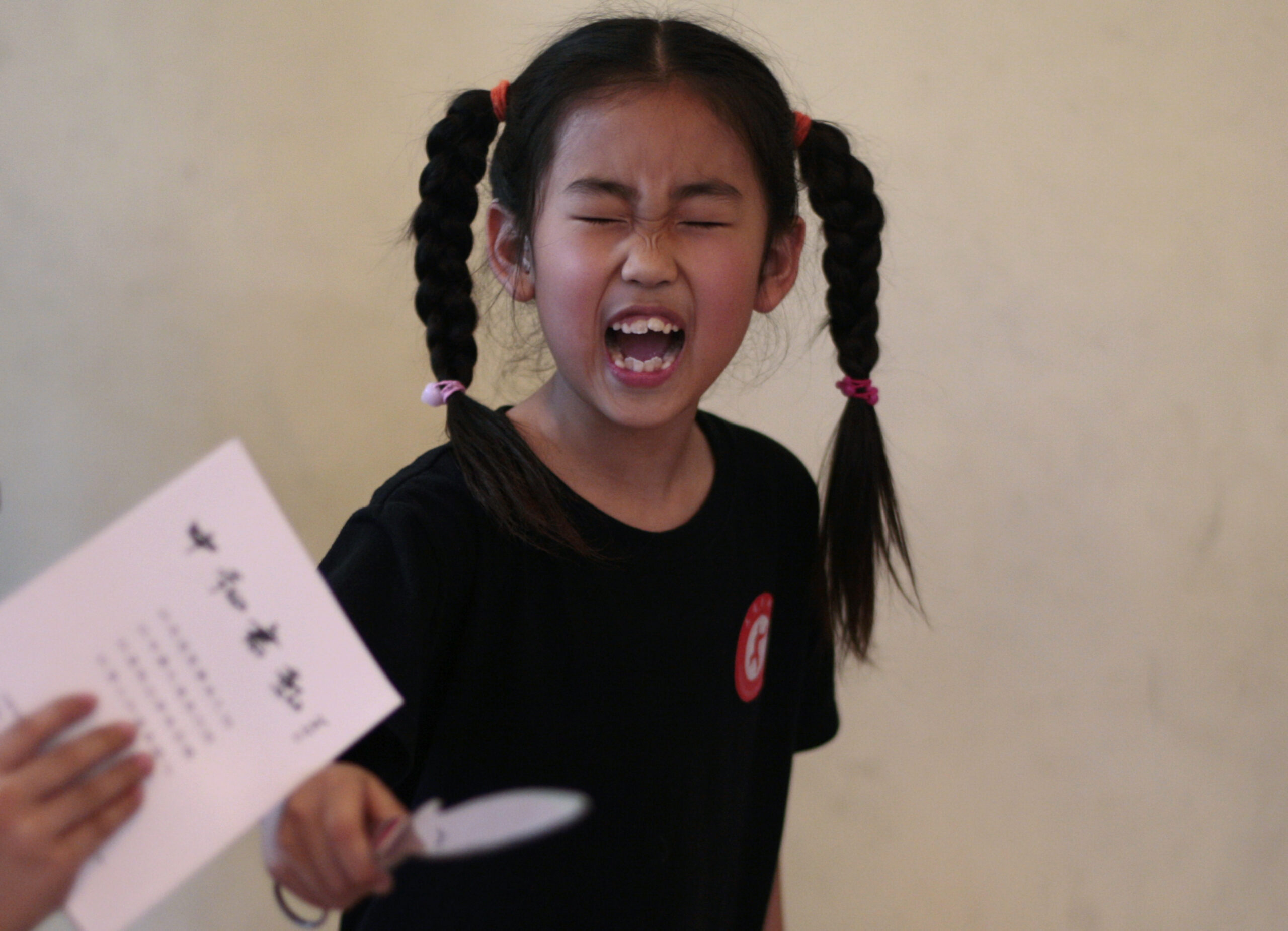 A Chinese School girl, reacts holding a knife during a self defence course at Changzheng Kung-fu School in Beijing, China. (AP/Muhammed Muheisen)