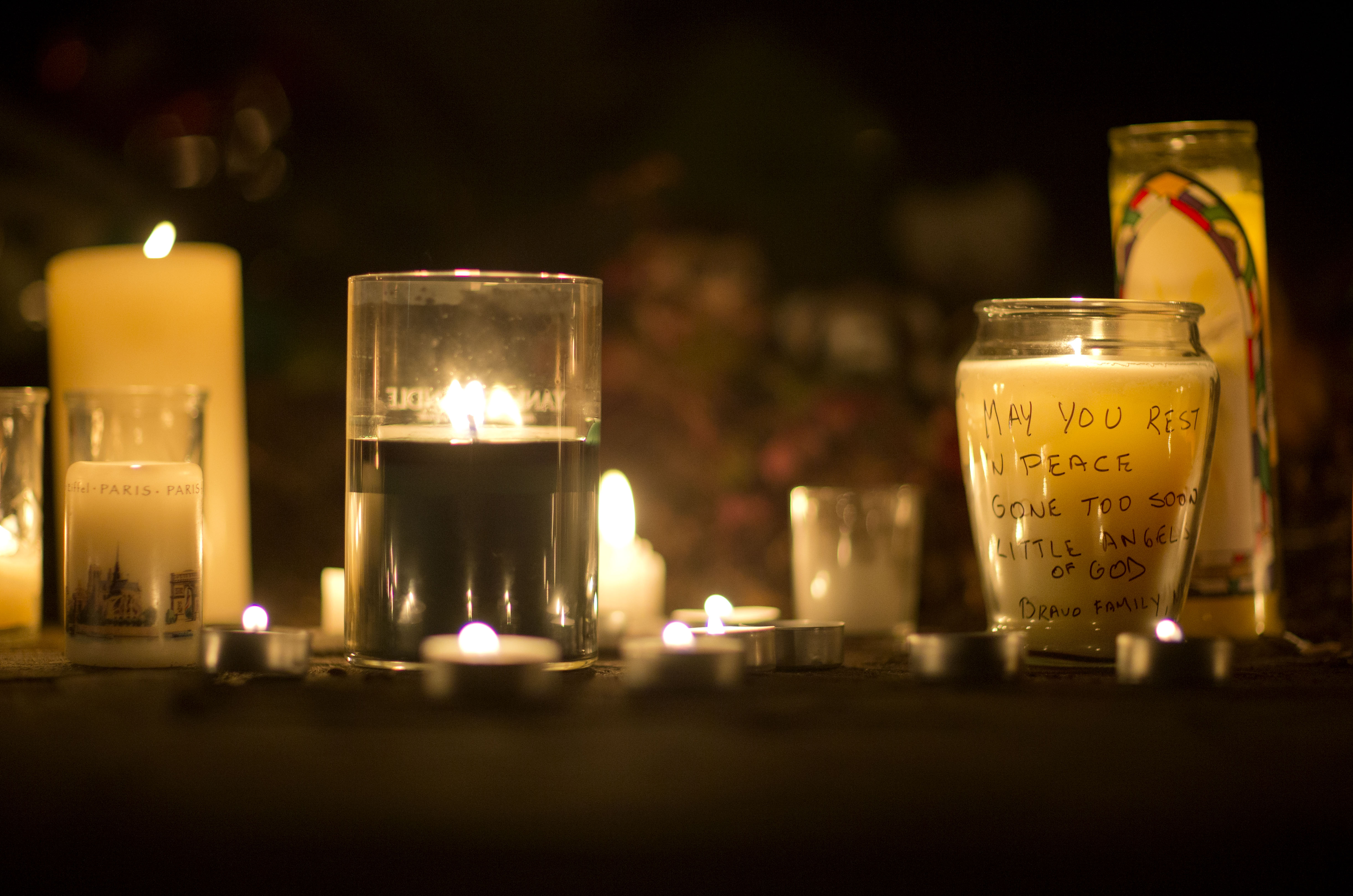 A message is seen on a candle outside the St. Rose of Lima Roman Catholic Church, Saturday, in Newtown, Conn. (AP/David Goldman)