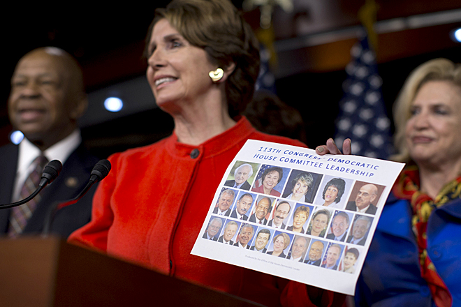 Nancy Pelosi holds up photos of the 113th Congress Democratic committee leadership members during a news conference to tout the party's diversity, Dec. 5, 2012. (AP/Evan Vucci)
