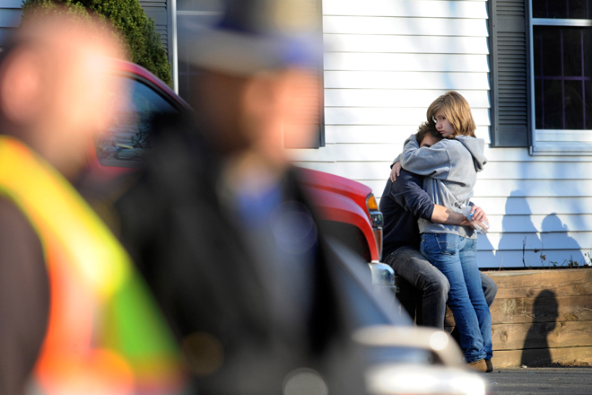 People embrace at a firehouse staging area for family around near the scene of a shooting at the Sandy Hook Elementary School in Newtown, Conn., Friday, Dec. 14, 2012. (AP Photo/Jessica Hill)