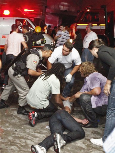 People help an injured man, victim of a fire in a club in Santa Maria city, Rio Grande do Sul state,  Brazil. (AP/Agencia RBS)
