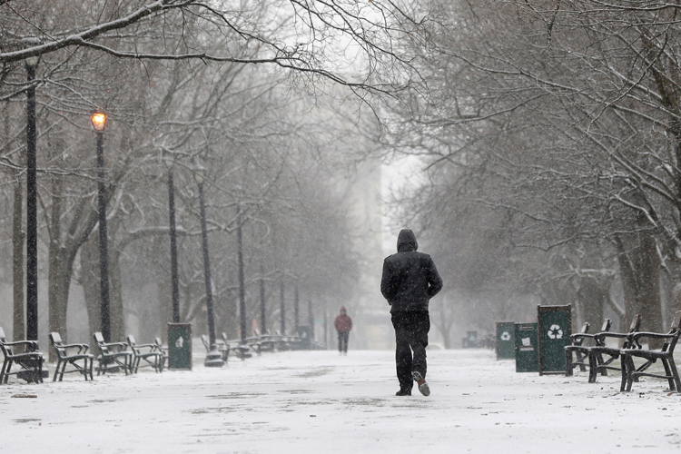 A pedestrian walks through the snow in Washington Park on Friday, Feb. 8, 2013, in Albany, N.Y. (AP/Mike Groll)