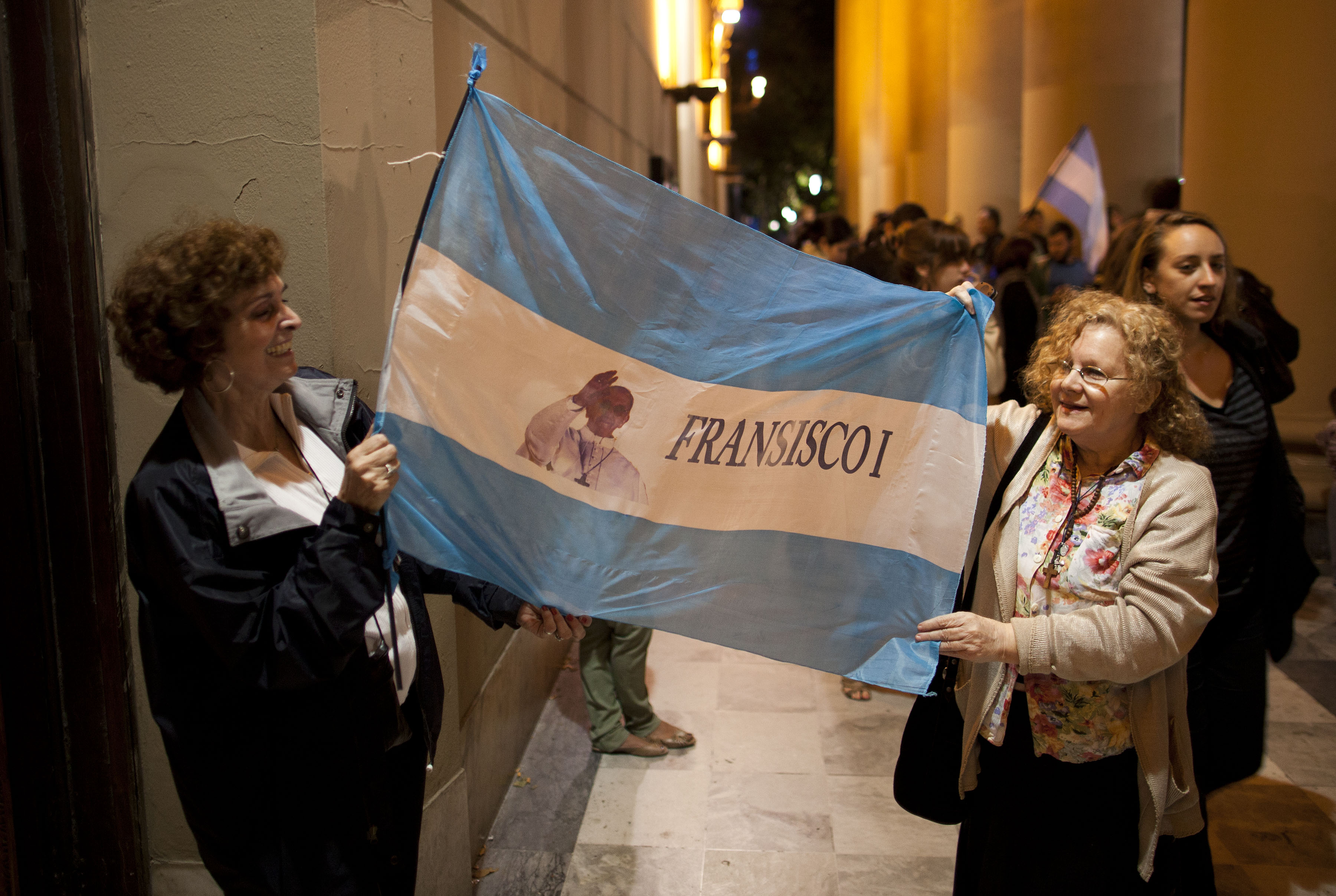 Faithful hold up an Argentine flag with an image of Buenos Aires' Archbishop Jorge Bergoglio that reads in Spanish "Francisco I" outside the Metropolitan Cathedral as people gather in Buenos Aires, Argentina. (AP/Ivan Fernandez)