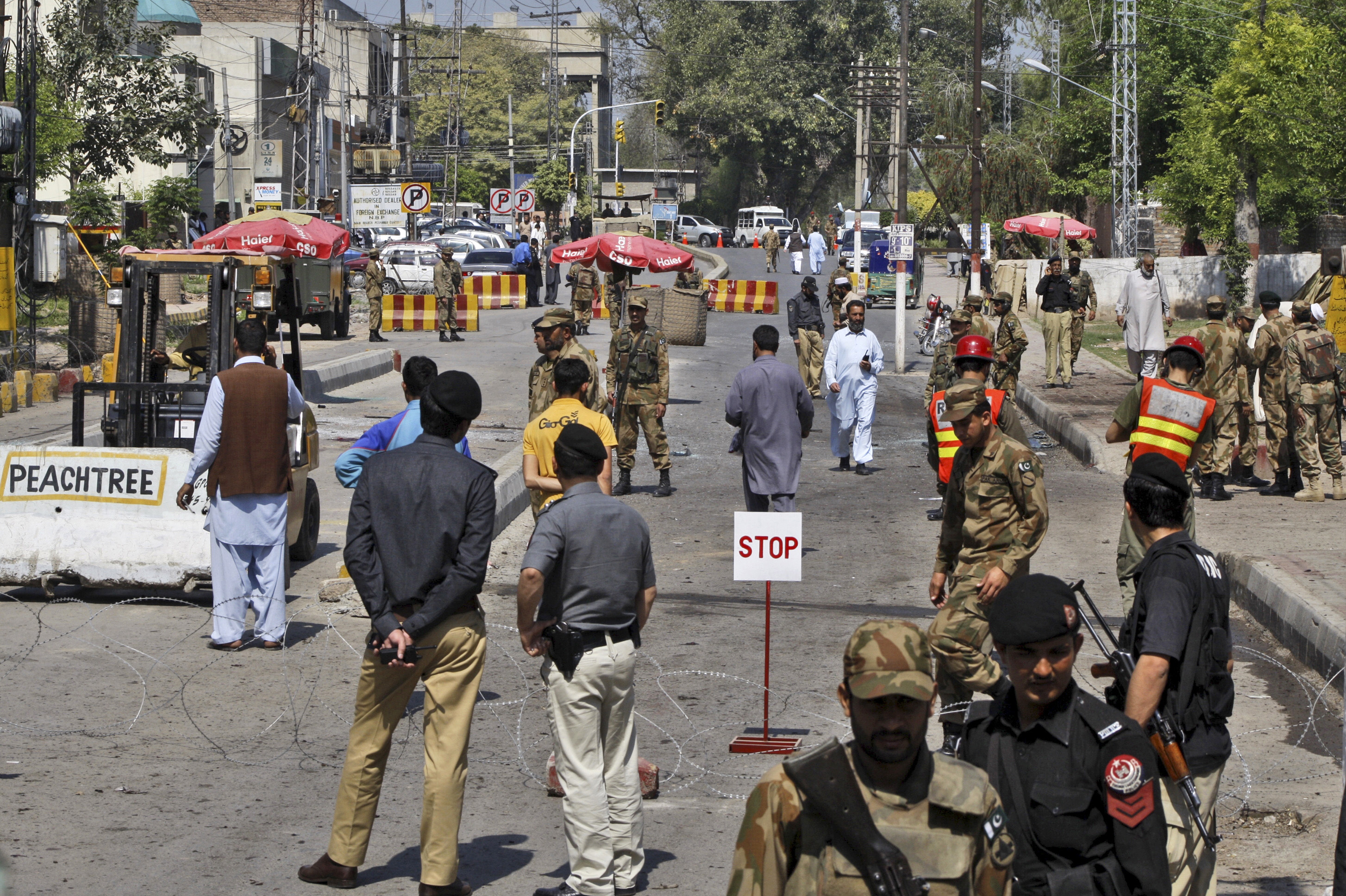 Pakistani security officers gather at the site of a suicide bombing, in Peshawar, Pakistan, Friday, March 29, 2013. (AP/Mohammad Sajjad)