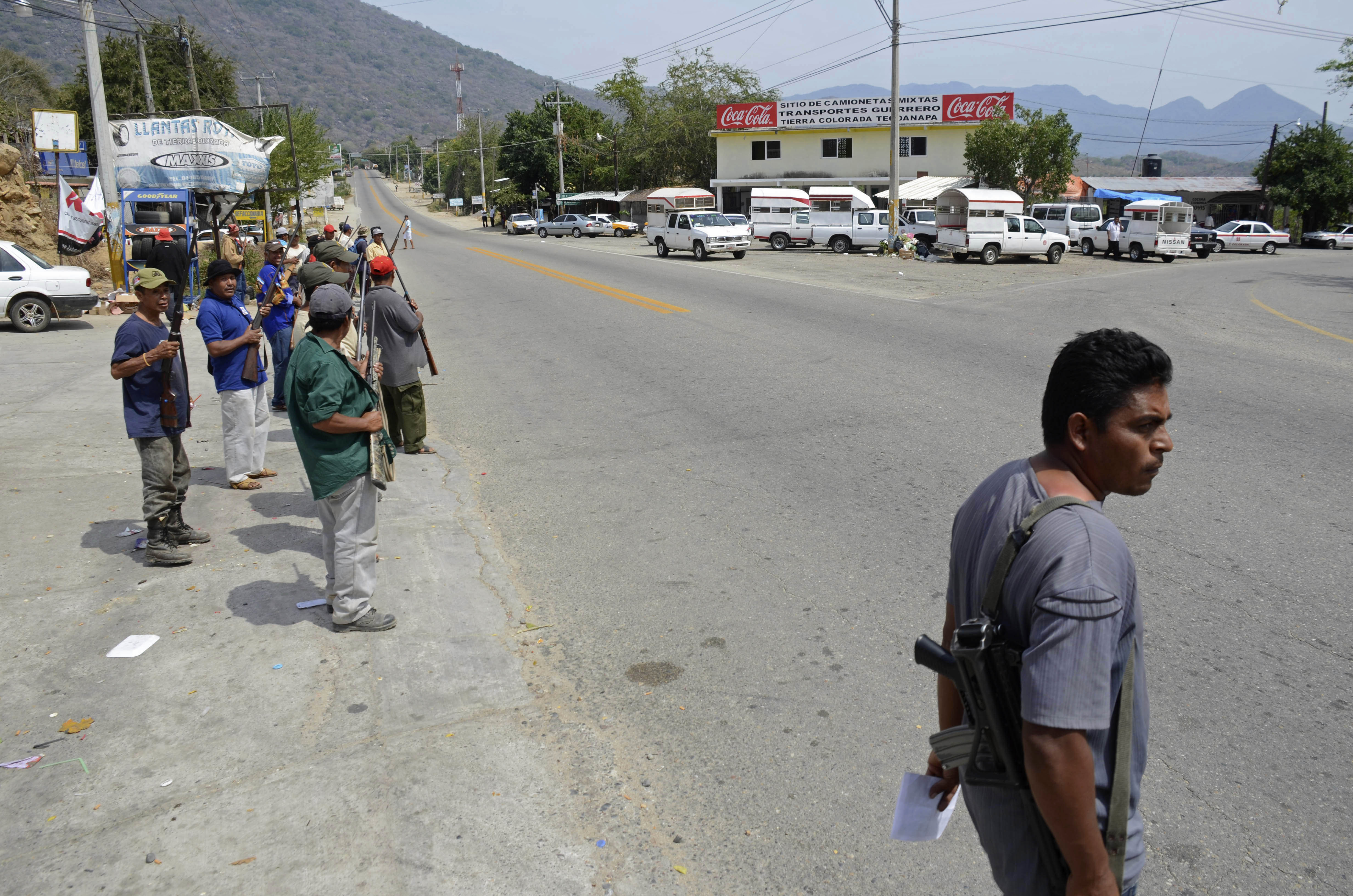 A group of armed vigilantes stand at the entrance to the town of Tierra Colorada, Mexico, Wednesday, March 27, 2013. (AP/Bernandino Hernandez)