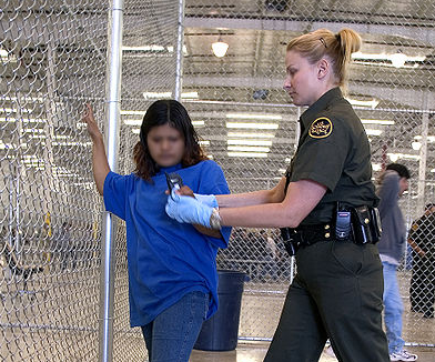 Border Patrol agent conducts a pat down of a female Mexican being placed in a holding facility (Wikimedia/DHS)