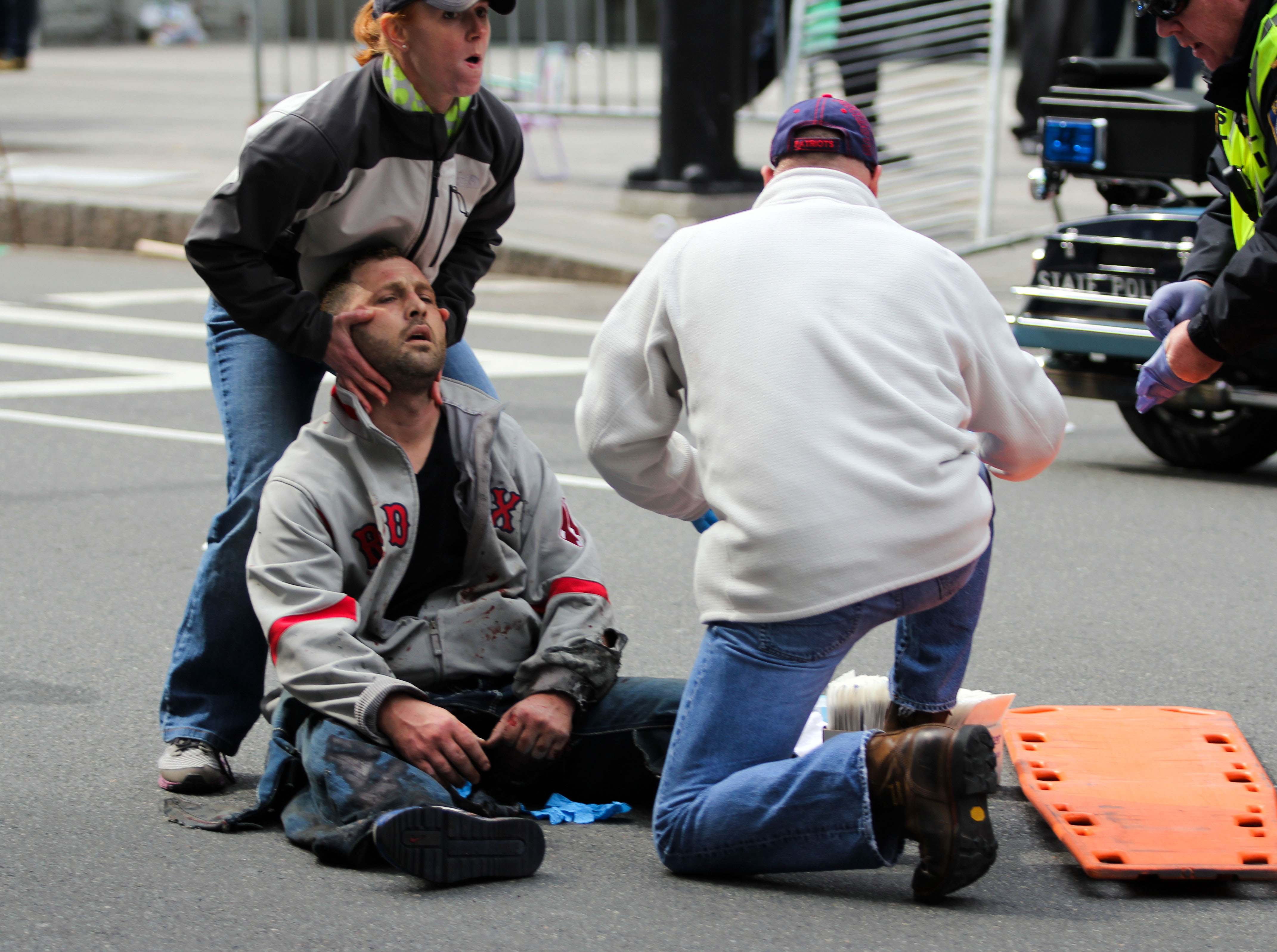 People assist an injured after an explosion at the 2013 Boston Marathon in Boston, Monday, April 15, 2013. (AP/The Daily Free Press, Kenshin Okubo)