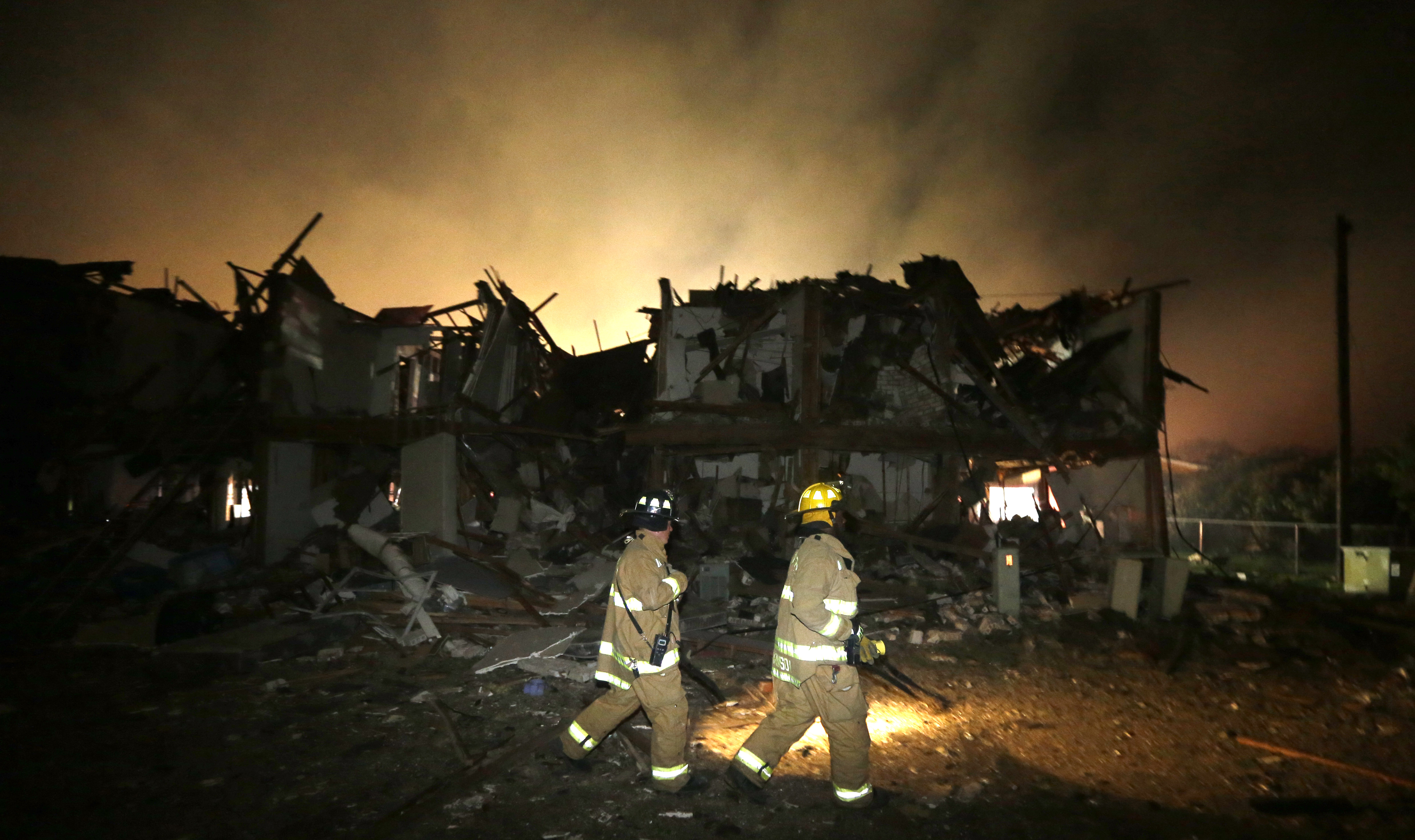 Firefighters check a destroyed apartment complex near the fertilizer plant that exploded earlier in West, Texas, in this photo made early Thursday, April 18, 2013. (AP/LM Otero)