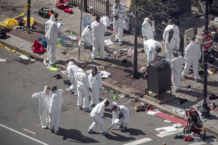 Investigators survey the site of a bomb blast on Boylston Street a day after two explosions hit the Boston Marathon in Boston, Massachusetts April 16, 2013. (Reuters/Adrees Latif)