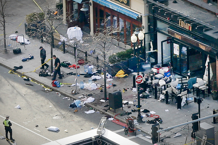 One of the blast sites on Boylston Street near the finish line of the 2013 Boston Marathon is investigated and guarded by police in the wake of two blasts in Boston Monday, April 15, 2013. (AP Photo/Elise Amendola) (Elise Amendola)