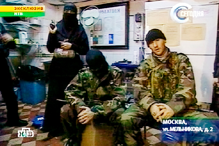A man identified as Movsar Barayev, reported to be a leader of armed Chechens, who seized a crowded Moscow theater, right, is seen with another male captor, center, and a woman captor, left,  somewhere inside  the theater, Moscow, in this early Friday, Oct. 25, 2002 image from television by Russia's NTV. (AP)