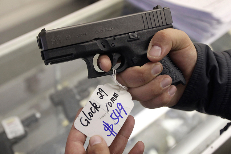 A customer looks over a Glock 29 10mm hand gun at the Guns-R-Us gun shop in Phoenix, Arizona, December 20, 2012. (Reuters/Ralph Freso)