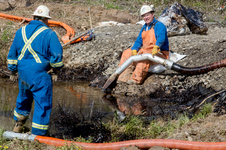 Emergency crews work to clean up an oil spill near Interstate 40 in Mayflower, Arkansas March 31, 2013. (Reuters/Jacob Slaton)