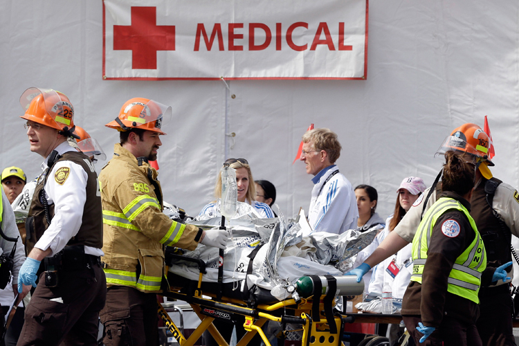 Medical personnel work outside the medical tent in the aftermath of two blasts which exploded near the finish line of the Boston Marathon in Boston, Monday, April 15, 2013. (AP/Elise Amendola)