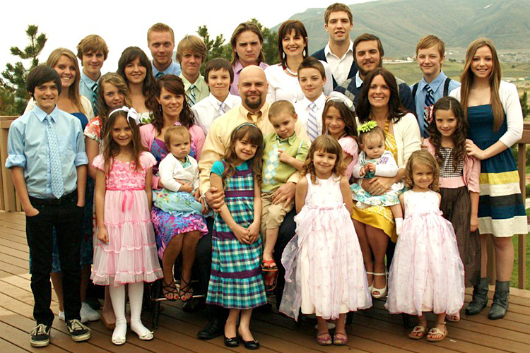 Photo of author with his three wives and 24 children