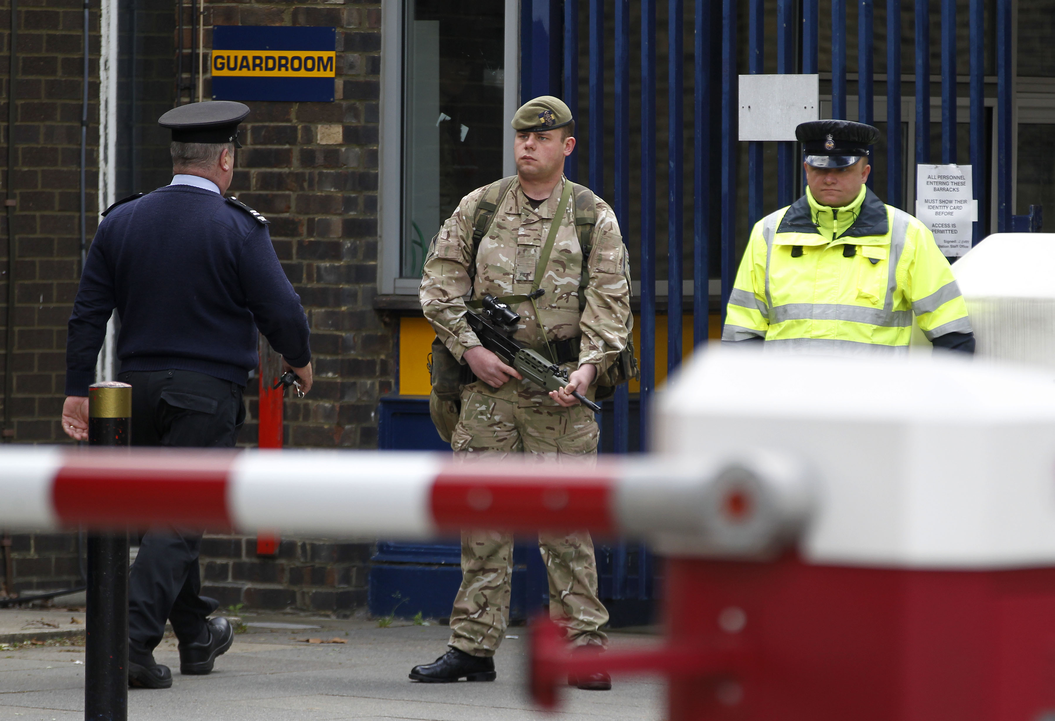 An armed soldier stands guard at the gate of the Royal Artillery Barracks near the scene of a terror attack in Woolwich, southeast London, Thursday, May 23, 2013. (AP/Sang Tan)