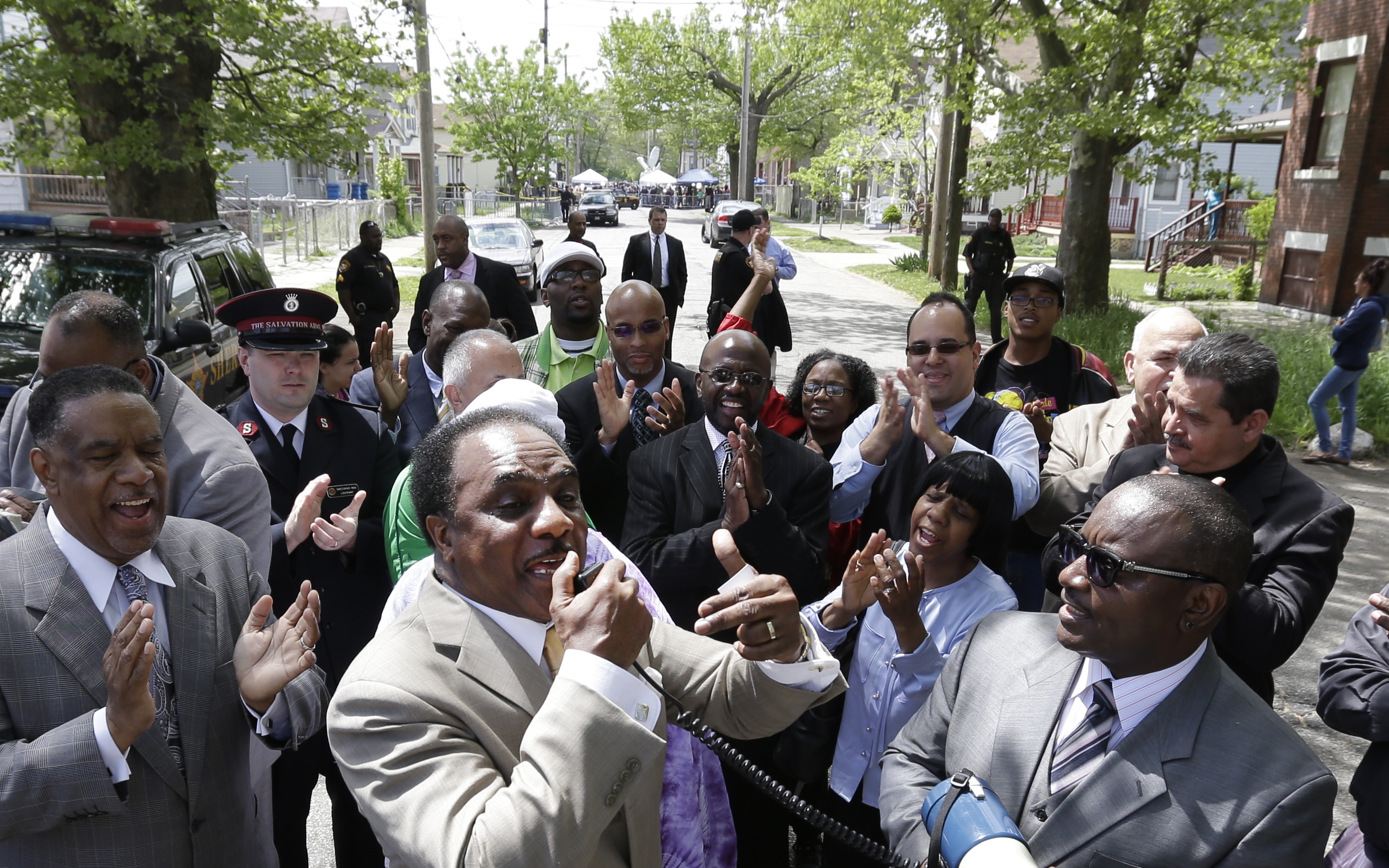 Pastor Larry Harris, center, leads a prayer vigil near the home where three women held captive for a decade, in Cleveland, Ohio, Wednesday, May 8, 2013. (AP/David Duprey)