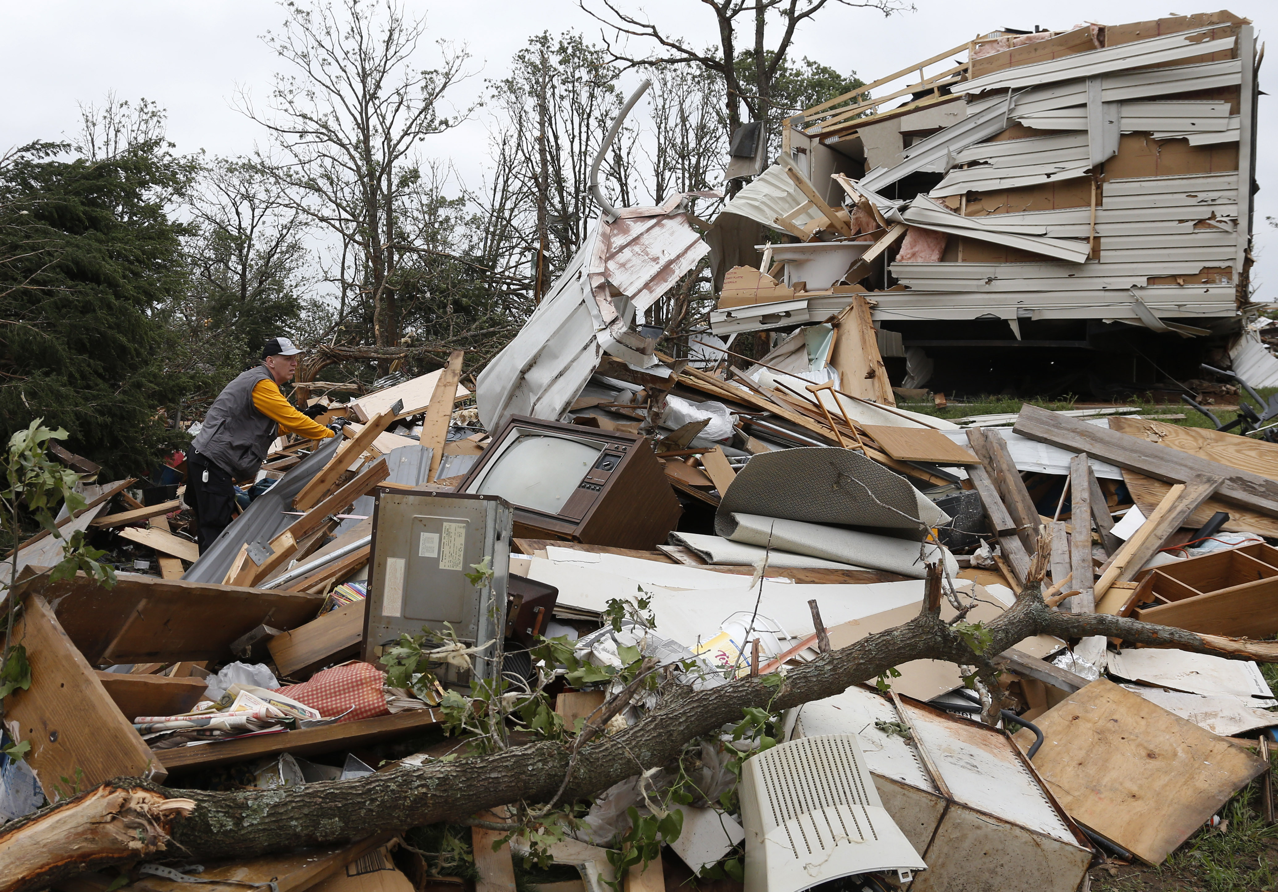 Lee Hoyle, of Chickasaw Nation search and rescue, digs through the debris of a mobile home in the Steelman Estates Mobile Home Park, destroyed by Sunday's tornado, near Shawnee, Okla., Monday, May 20, 2013. (AP/Sue Ogrocki)
