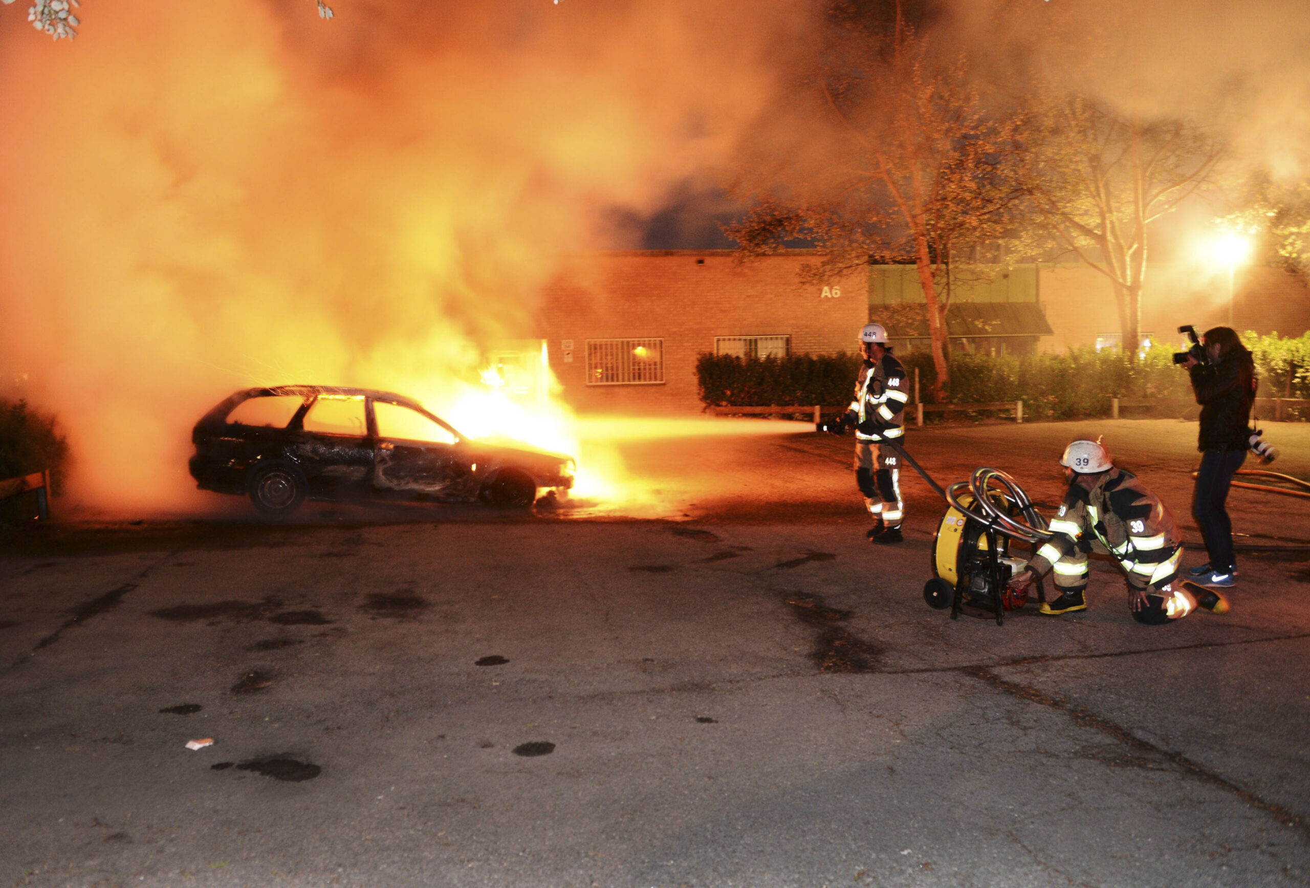 Firefighters extinguish a burning car, following riots in the Stockholm suburb of Kista late May 21, 2013. (Reuters/Fredrik Sandberg/Scanpix)