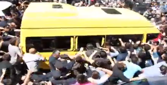 Violent protestors mob buses escorting gay rights marchers to safety. (YouTube)