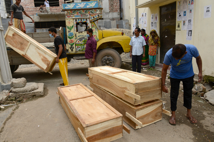 Workers off-load coffins at a morgue on Wednesday May 1, 2013 in Dhaka, Bangladesh. (AP/Ismail Ferdous)