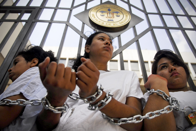 Women stand chained together outside the Supreme Court during a protest in San Salvador May 15, 2013. (Reuters/Ulises Rodriguez)
