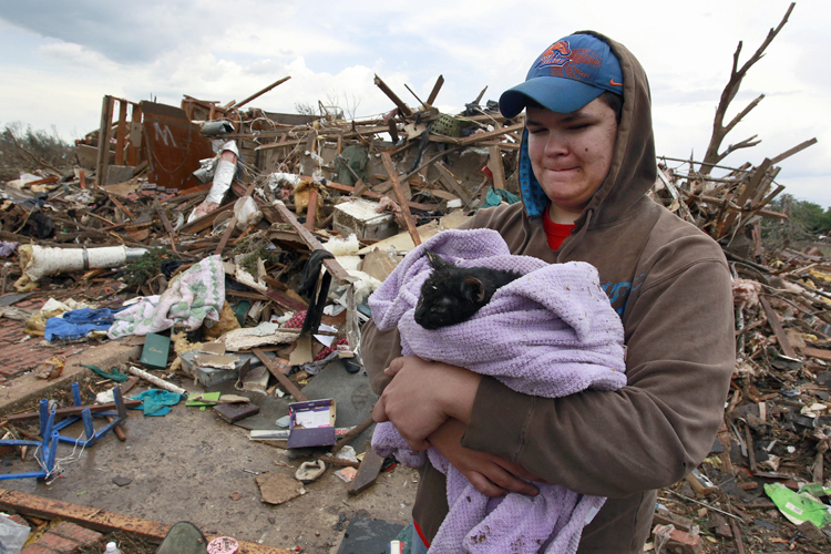 Austin Brock holds cat Tutti after the animal was retrieved from the rubble of Brock's home, which was demolished a day earlier in Moore, Okla., May 21, 2013. (AP/Brennan Linsley)