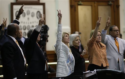 Sen. Wendy Davis, D-Fort Worth, center, who tries to  filibuster an abortion bill, hold up a no vote as time expires, Wednesday, June 26, 2013, in Austin, Texas. Amid the deafening roar of abortion rights supporters, Texas Republicans huddled around the Senate podium to pass new abortion restrictions, but whether the vote was cast before or after midnight is in dispute. If signed into law, the measures would close almost every abortion clinic in Texas.  (AP Photo/Eric Gay) (AP)