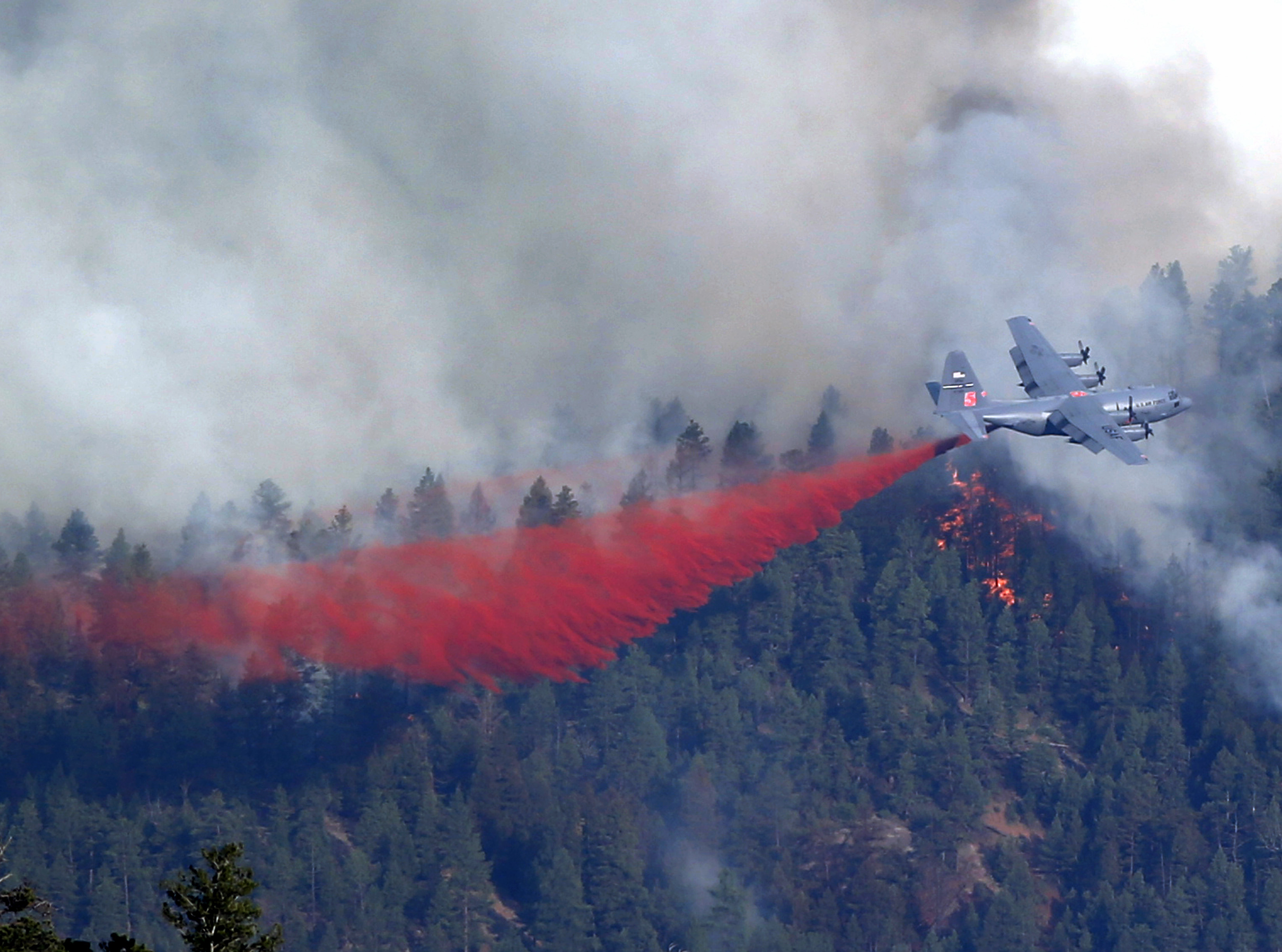 A military C-130 drops a load of fire retardant on a wildfire near Pine, Colo., on Wednesday, June 19, 2013. (AP/Ed Andrieski)