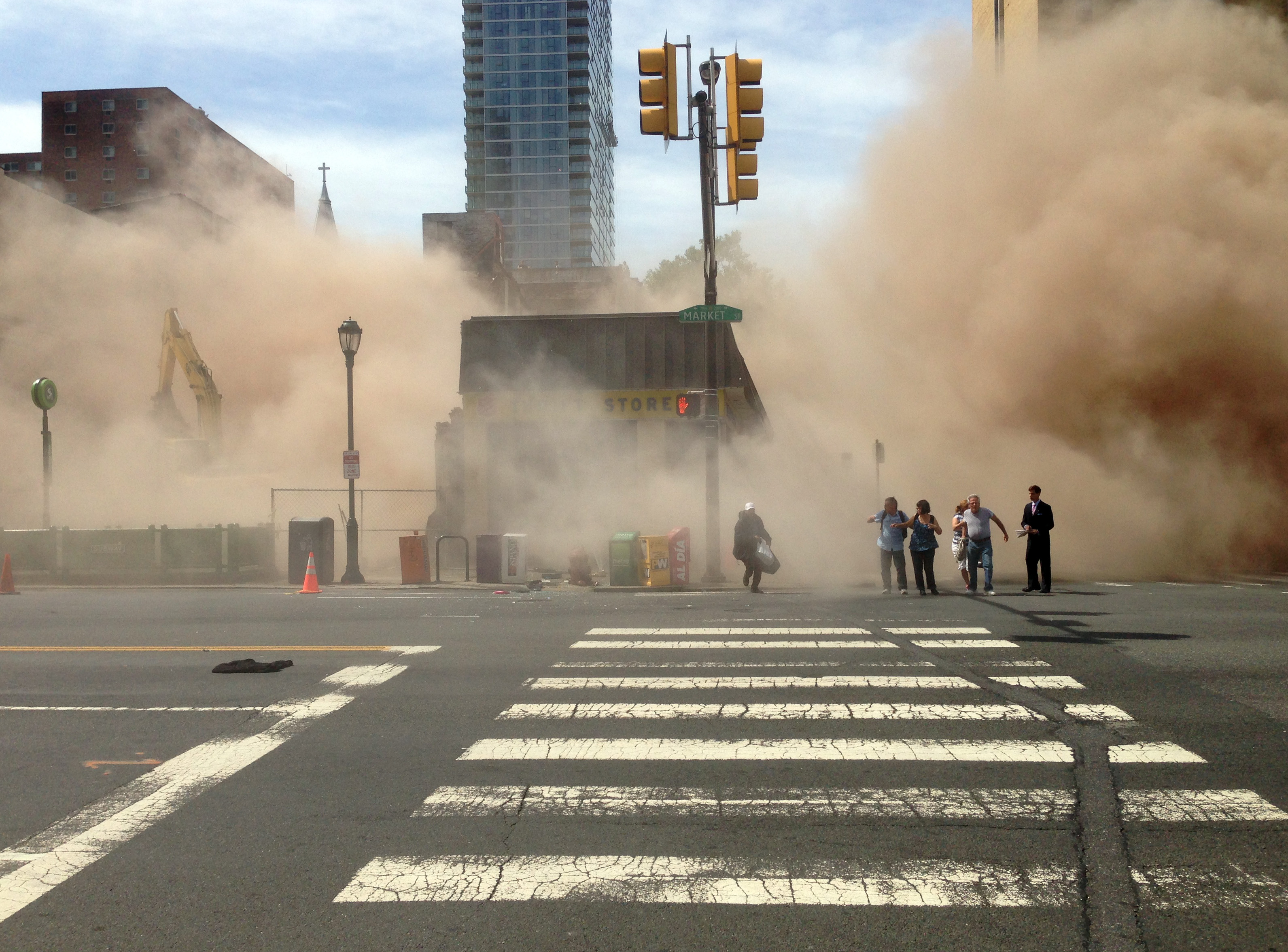 A dust cloud rises as people run from the scene of a building collapse on the edge of downtown Philadelphia on Wednesday, June 5, 2013. (AP/Jordan McLaughlin)