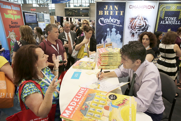 Author John Bemelmans Marciano autographs copies of his book at Book Expo America, May 30, 2013 in New York. (AP/Mark Lennihan)