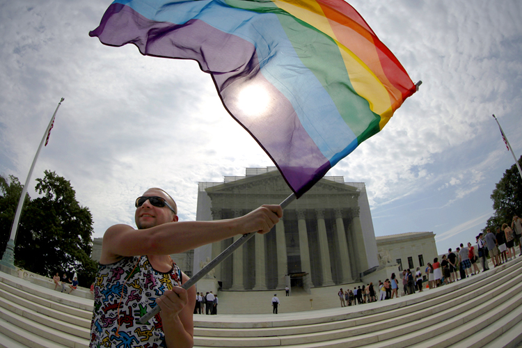 A gay marriage supporter waves a rainbow flag in anticipation of U.S. Supreme Court rulings, June 24, 2013. (Reuters/Jonathan Ernst)