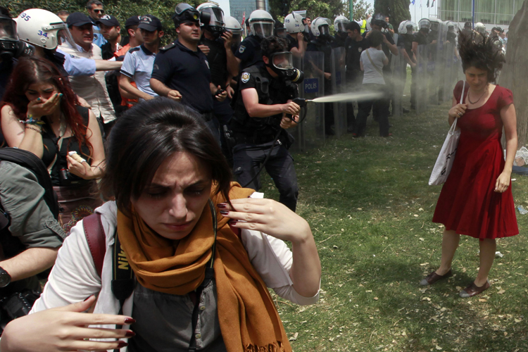 A Turkish riot policeman uses tear gas in Taksim Square, Istanbul May 28, 2013. (Reuters/Osman Orsal)