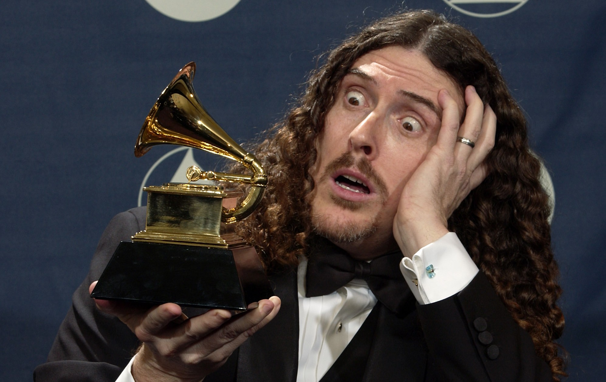 "Weird Al" Yankovic clowns around with the award he won for best comedy album for "Poodle Hat" at the 46th Annual Grammy Awards, Sunday, Feb. 8, 2004, in Los Angeles. (AP Photo/Reed Saxon) (AP/Reed Saxon)