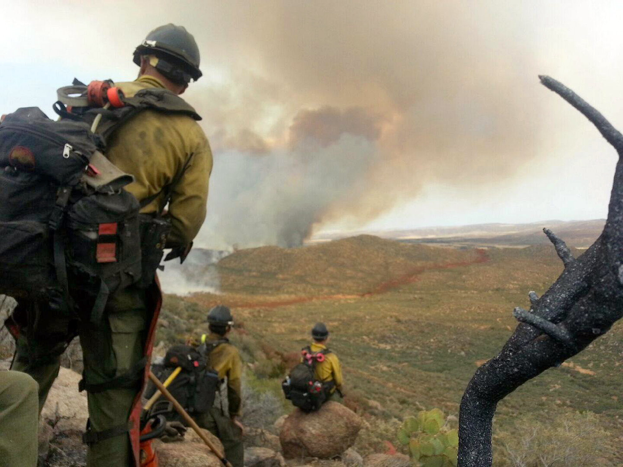 In this photo shot by firefighter Andrew Ashcraft, members of the Granite Mountain Hotshots watch a growing wildfire that later swept over and killed the crew of 19 firefighters near Yarnell, Ariz., Sunday, June 30, 2013. (AP/Courtesy of Juliann Ashcraft)