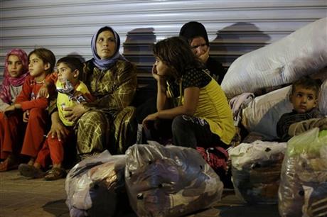 Syrian refugees stand sit in front of a closed shop in Reyhanli, Turkey, Saturday, Aug. 31, 2013. U.S. President Barack Obama said he has decided that the United States should take military action against Syria in response to a deadly chemical weapons attack, but he said he will seek congressional authorization for the use of force. (AP Photo/Gregorio Borgia)