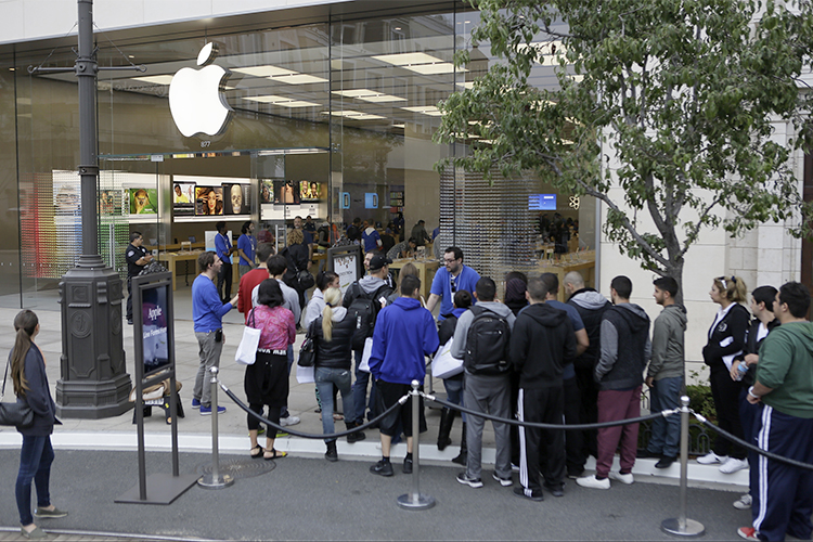 Customers wait in line to buy the latest versions of the iPhone during the opening day of sales of the iPhone 5s and iPhone 5C at the Apple store in Glendale, Calif., Sept. 20, 2013. (AP/Damian Dovarganes)