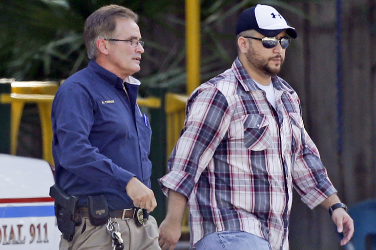 George Zimmerman, right, is escorted by a Lake Mary police officer, Sept. 9, 2013, in Lake Mary, Fla. (AP/John Raoux)