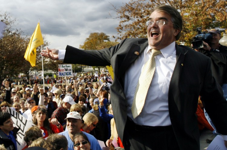 FILE - In this Nov. 5, 2009, file photo Rep. John Culberson, R-Texas, flings a  copy of the health care bill out into the crowd during a health care reform rally on Capitol hill in Washington.  (AP Photo/Jose Luis Magana, File) (Associated Press)