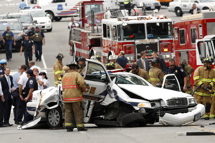 Rescue personnel stand around a smashed U.S. Capitol Police car following a shooting near the U.S. Capitol in Washington, October 3, 2013. (Reuters/Kevin Lamarque)
